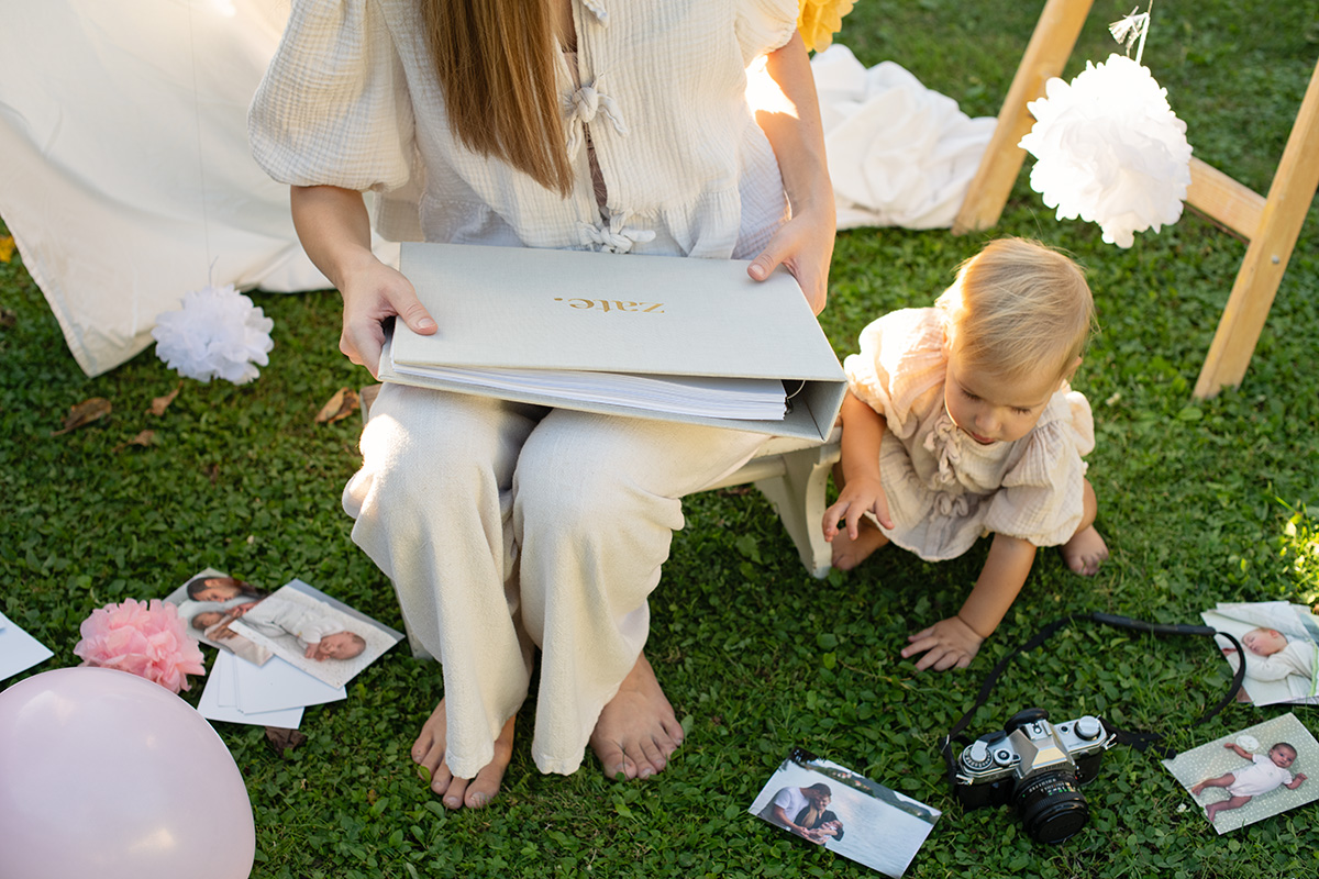 Zabava za rojstni dan - mamica drži v roki dojenčkov ablum zate 